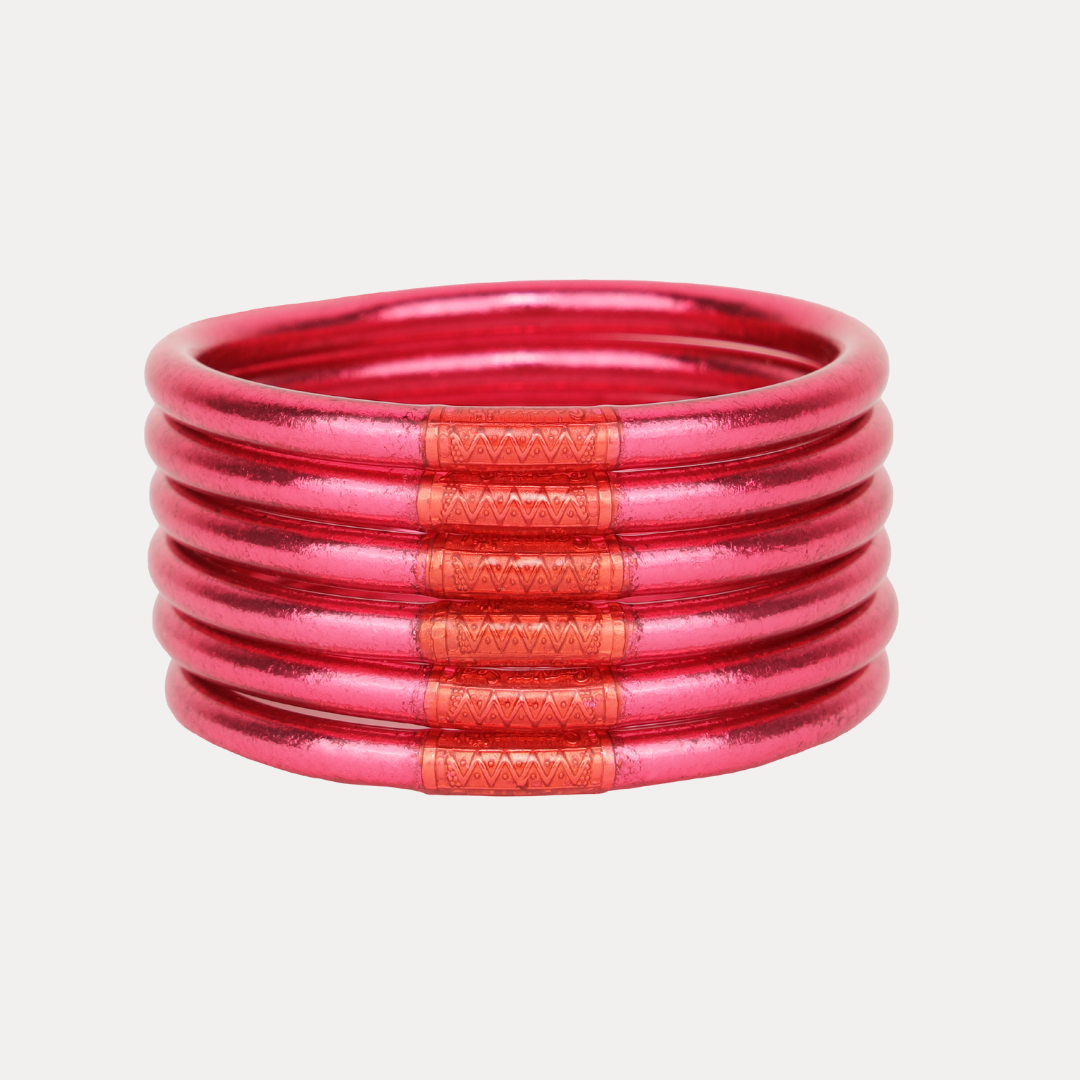 Stack of pink and orange bangles on a light gray background